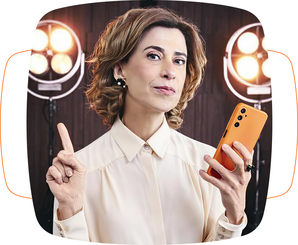 Imagem de uma mulher em um estúdio, segurando um celular laranja